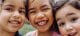 three toddlers smiling in an indoor obstacle course for kids